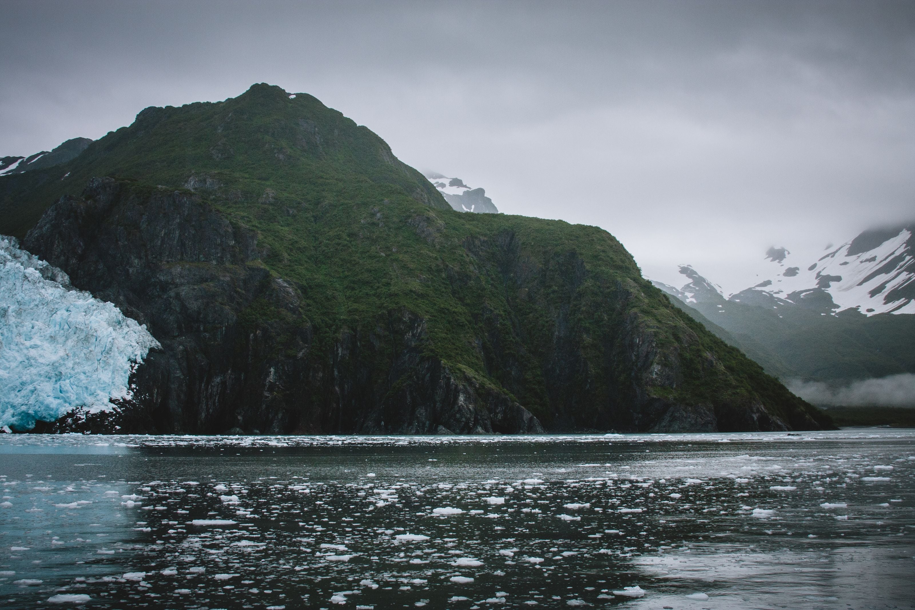 A glacier and rugged mountains above Alaskan waters